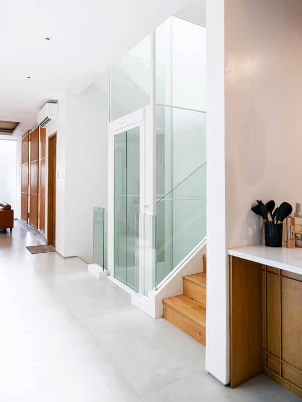 Glazed Swift Lite shaft rising beside timber stairs in a bright hallway
