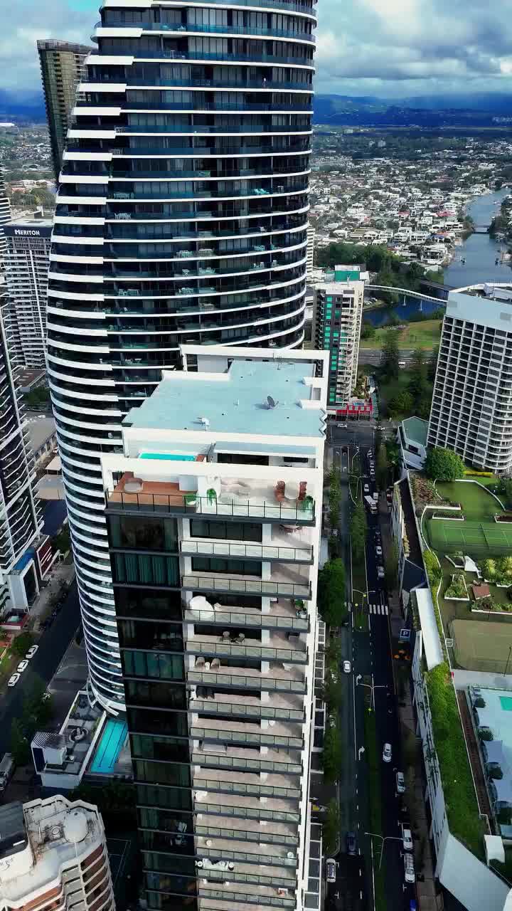Aerial view of Broadbeach high-rise towers on the Gold Coast, looking down over rooftop pools, balconies and the street