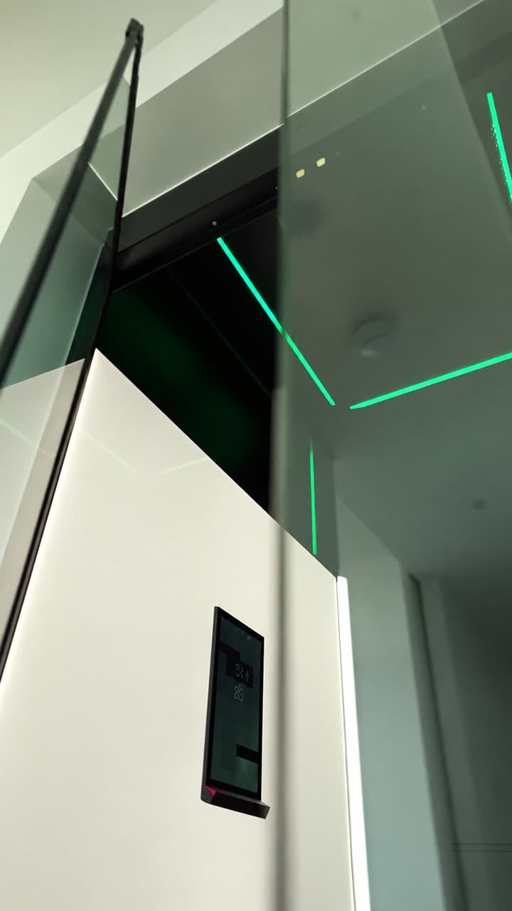 Open glass door into a Swift Pro XL cabin corner with white panels, touchscreen and green RGB ceiling lighting in a Broadbeach penthouse