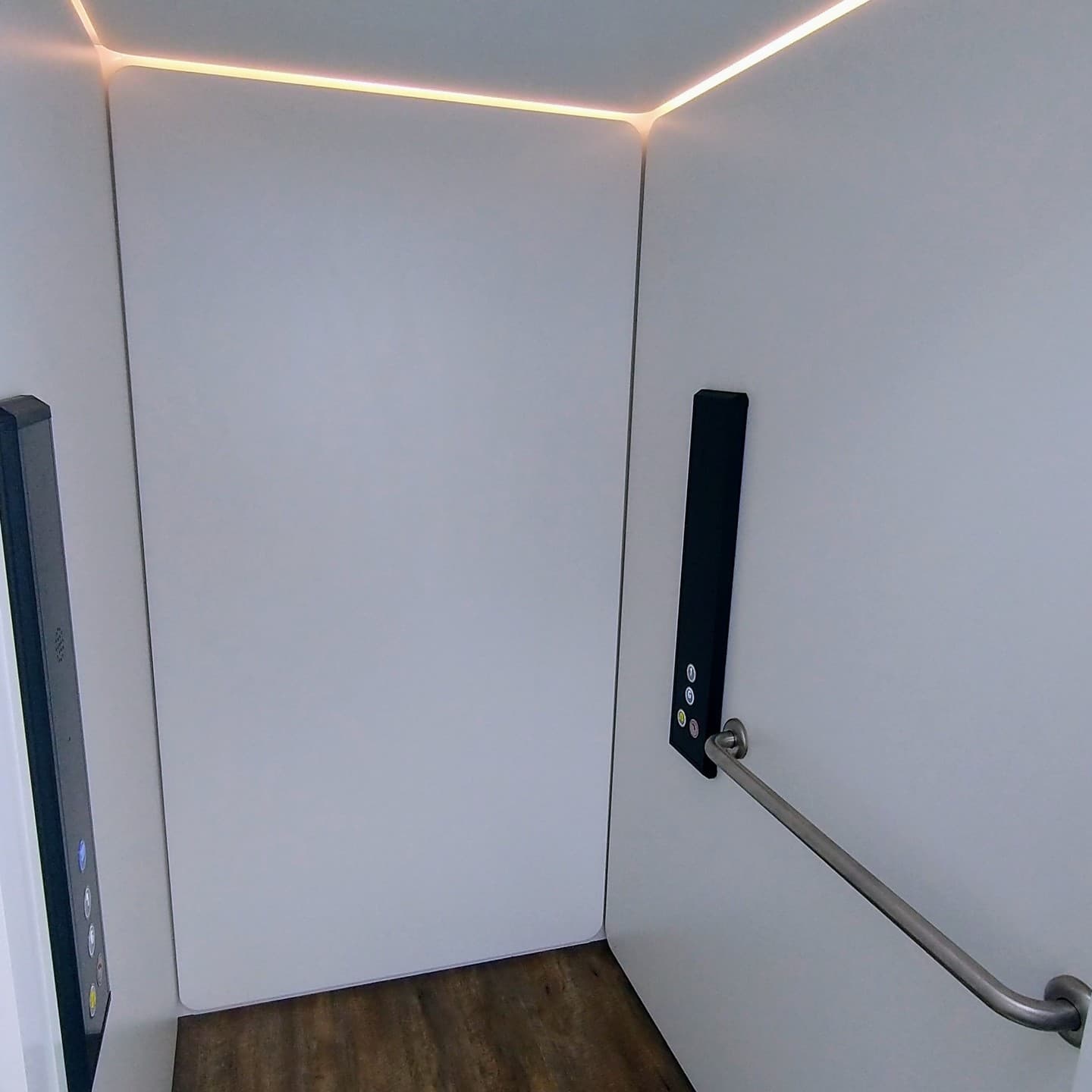 A Phoenix home lift cabin in a Bundaberg, Queensland home, white panels, LED strip, handrail, control panels and wood floor