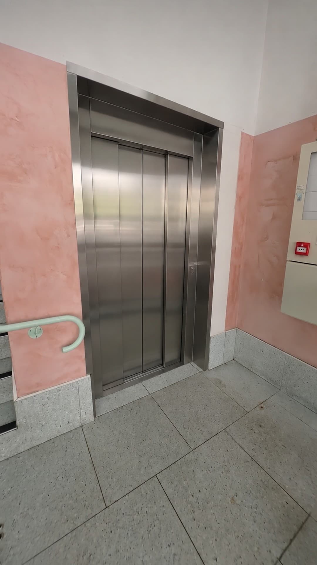 Closed brushed stainless doors of the Custom Orion lift set in a textured pink wall at Burleigh Pavilion, Gold Coast