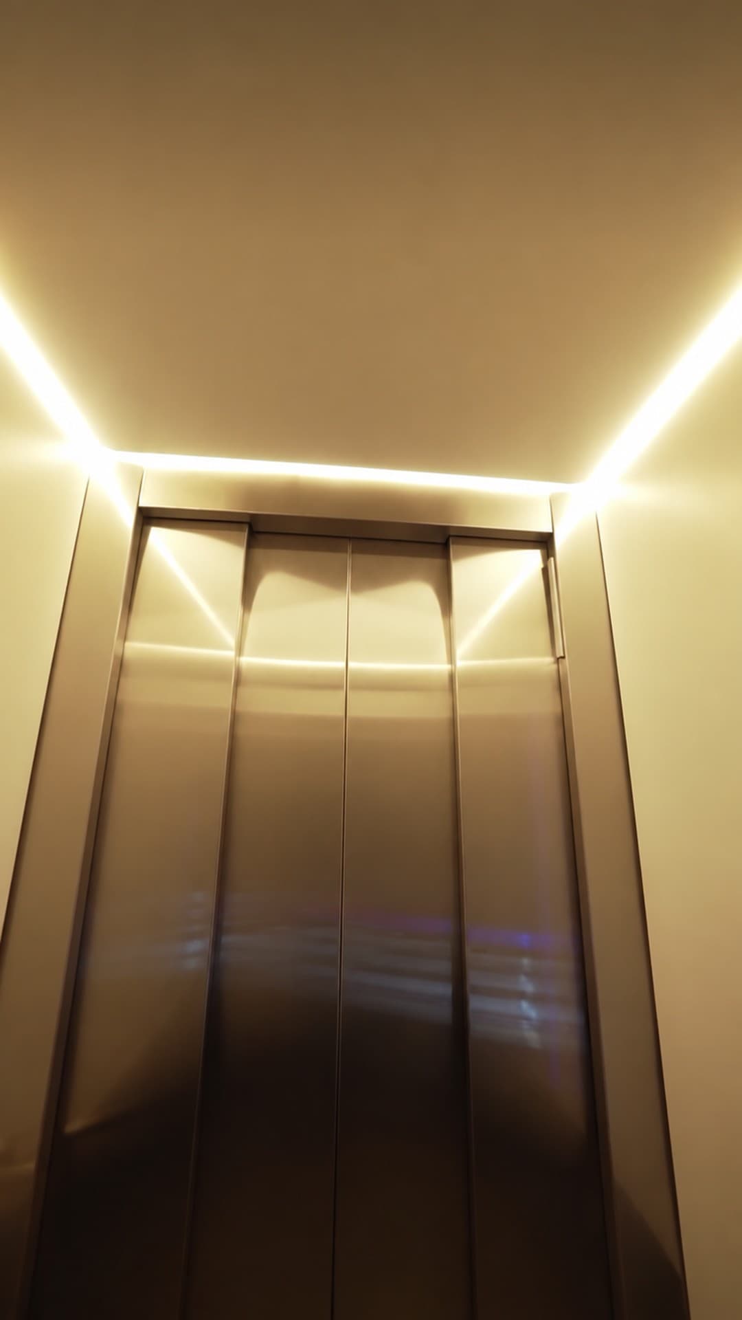 Closed champagne-gold cabin doors of the Custom Orion lift at Burleigh Pavilion, Gold Coast, lit by a warm ceiling strip