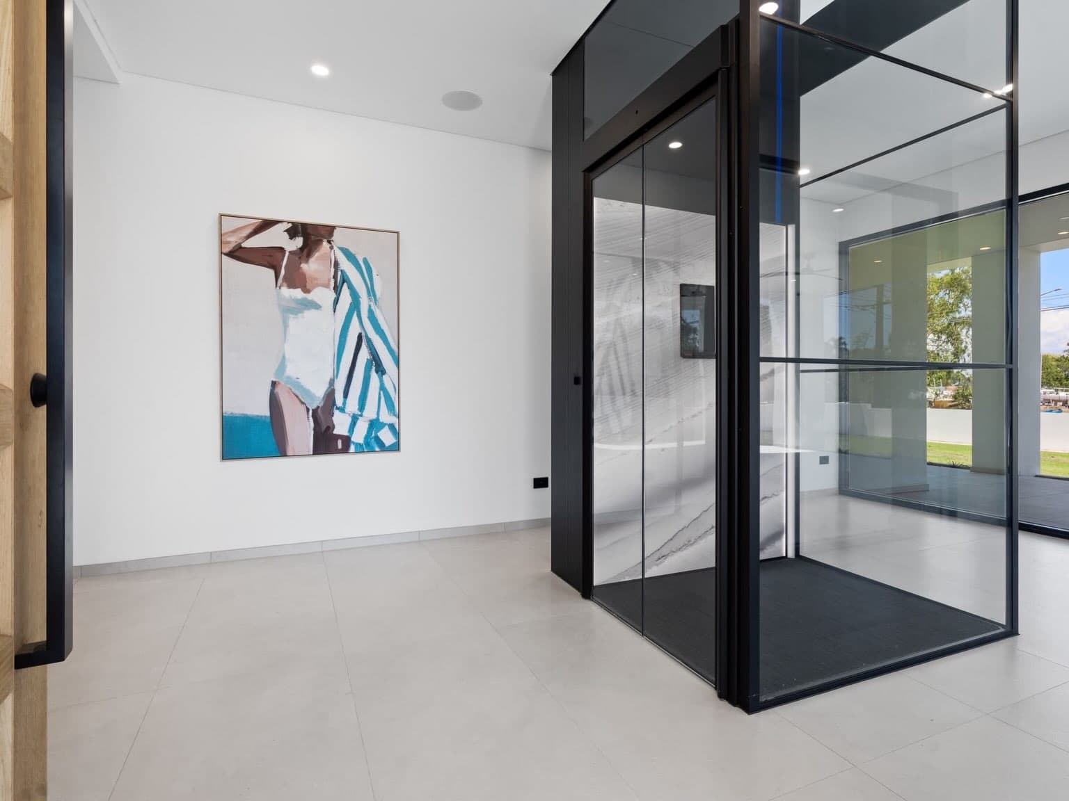 Jet Black Swift Pro glass shaft with Concrete Artwall, standing open beside coastal artwork in a bright Darwin home