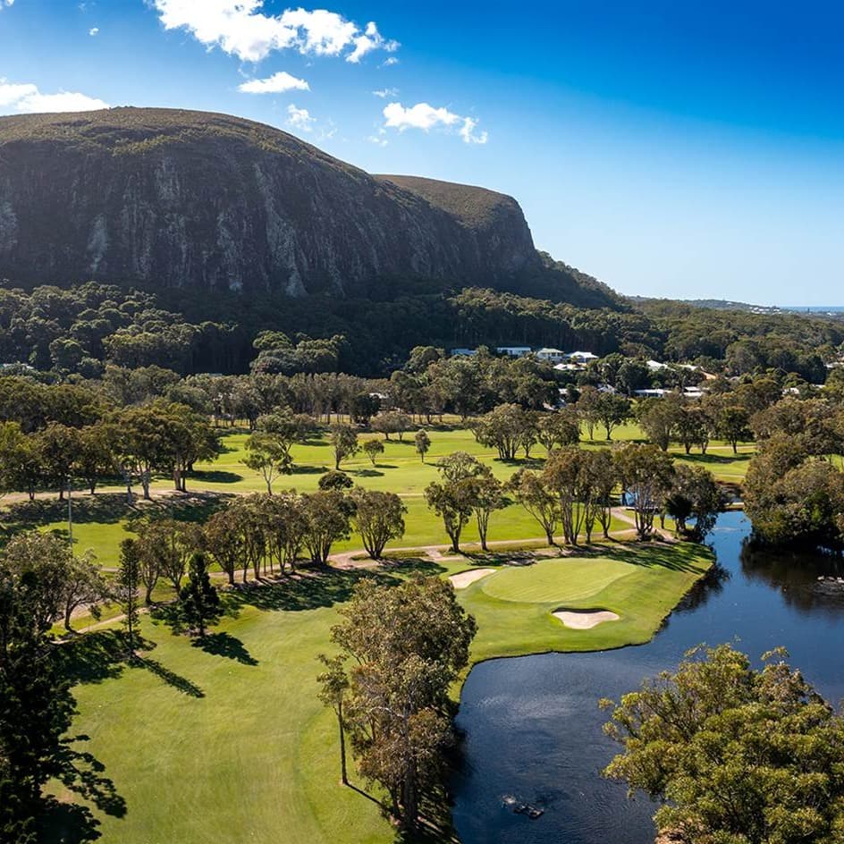 Aerial view of Mt Coolum Golf Course on the Sunshine Coast, with fairways, a water hazard and Mt Coolum behind — no lift in frame