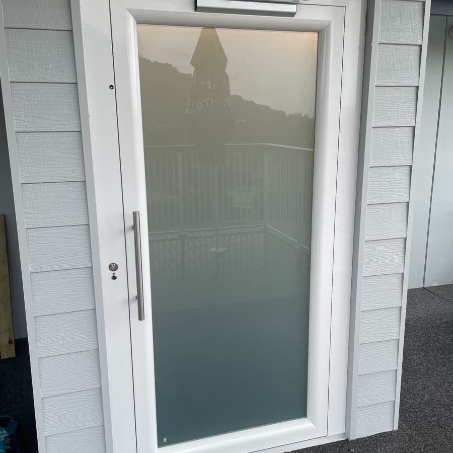 A Phoenix lift at Mt Coolum Golf Course on the Sunshine Coast, close-up of the white-framed frosted landing door in a grey weatherboard shaft
