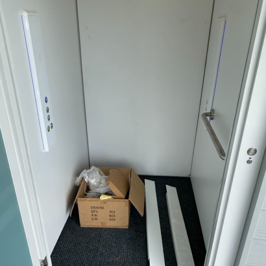 Phoenix lift cabin install in progress at Mt Coolum Golf Course, white panels, blue LED edge lighting, handrail, cardboard and trim still on the floor