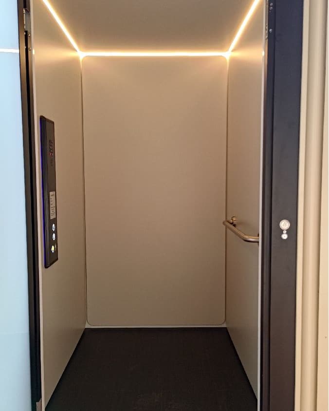 A Phoenix home lift in a Mt Tamborine, Queensland home, cabin interior with LED lighting, handrail and control panel