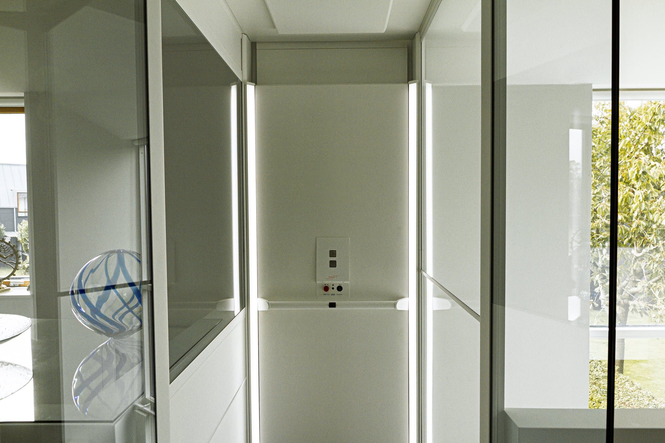 Swift Lite cabin in white, glass doors open onto a garden outlook