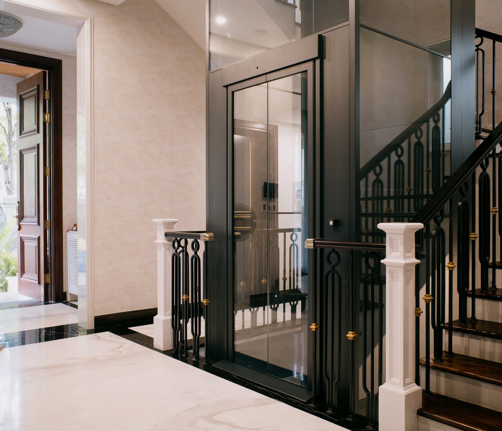 Swift Pro with a black frame and glass doors in a marble entry hall, beside an ornate staircase